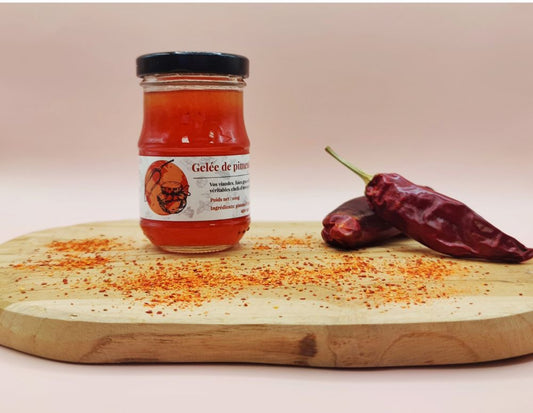 Gelée de piment d'Espelette AOP Origine France 100g, présentation dans un pot sur planche en bois avec piments d'Espelette entiers